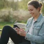 Hantera lån med mobilen smart En leende person som håller i en smartphone.